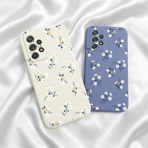 以下が含まれることがあります： 花柄の携帯電話ケース2つ。1つは白と黄色の花柄のオフホワイト、もう1つは白と黄色の花柄の青色です。どちらもカメラの切り抜きがあり、滑らかな仕上がりです。