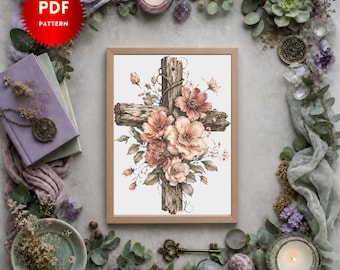 May include: A PDF pattern featuring a cross made of weathered wood, adorned with soft pink and peach-colored flowers and green leaves. The design is centered within a light-colored rectangular frame, showcasing a detailed floral arrangement.
