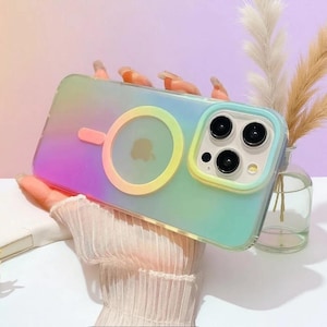 May include: A gradient-colored phone case with a MagSafe magnetic ring on the back. The case features a soft transition from purple to green and yellow, with a raised border around the camera lenses and a circular magnetic charging alignment ring.