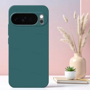 May include: A solid dark teal smartphone case featuring a horizontal camera cutout at the top. The cutout contains a black camera module with multiple lenses and a circular flash. The case has a smooth, matte finish and covers the back of the device.