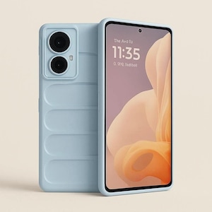 May include: A light blue smartphone case with a padded, quilted texture on the back and a raised camera housing featuring two circular lenses. The phone screen displays the time 11:35 and abstract orange and cream-colored graphic shapes.