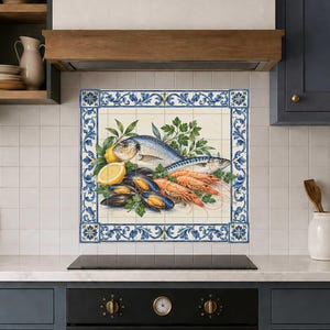 May include: A square decorative tile mural featuring a central illustration of fresh seafood including a whole fish, prawns, and mussels, accented with lemon slices and parsley. The artwork is framed by a blue and white floral border pattern.