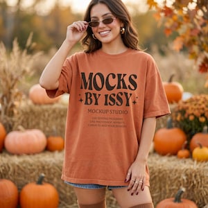 May include: A burnt orange short-sleeve t-shirt featuring the black text MOCKS BY ISSY MOCKUP STUDIO with small star icons. The shirt includes instructional text regarding the use of editing programs like Photoshop, Affinity, and Canva.
