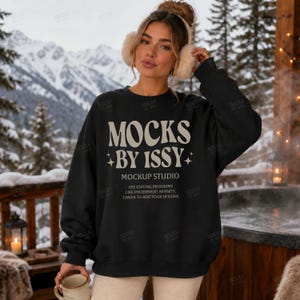Könnte beinhalten: Ein schwarzes langärmeliges Sweatshirt mit Rundhalsausschnitt und dem weißen Text MOCKS BY ISSY MOCKUP STUDIO USE EDITING PROGRAMS LIKE PHOTOSHOP, AFFINITY, CANVA TO ADD YOUR DESIGNS sowie beigen, flauschigen Ohrenschützern über einem Dutt.