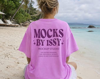 Mockup da camiseta Comfort Colors 1717 Neo Violet, vista traseira da camiseta na praia, mockup de camiseta para férias na praia.