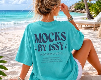 Mockup da parte de trás da camiseta Comfort Colors 1717 na cor verde-água, vista traseira da camiseta na praia, foto estilizada de camiseta para o verão com inspiração litorânea.