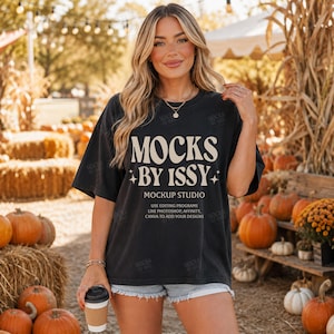 May include: A black short-sleeve t-shirt featuring the cream-colored text MOCKS BY ISSY MOCKUP STUDIO USE EDITING PROGRAMS LIKE PHOTOSHOP, AFFINITY, CANVA TO ADD YOUR DESIGNS with small star accents on the front of the garment.