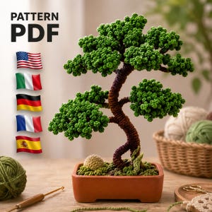 Könnte beinhalten: Ein gehäkelter Bonsai-Baum mit grünen Blättern und einem braunen Stamm, präsentiert in einem Terrakotta-Topf. Das Bild enthält den Text "PATTERN PDF" und Flaggen mehrerer Länder. Der Baum ist eine Miniaturdarstellung.