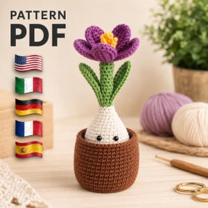 May include: A crocheted purple flower with a yellow center and green stem sits in a brown crocheted pot. The word "PATTERN PDF" is at the top left, with flags of the USA, Italy, Germany, France, and Spain.