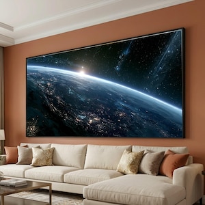 May include: A large rectangular wall art print featuring a panoramic view of Earth from space at night. The image displays the glowing city lights on the planet's surface, a bright horizon line, and a dark starry sky with deep blue tones.