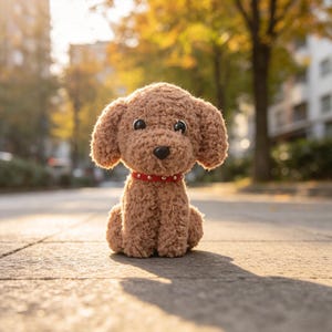 Könnte beinhalten: Ein braunes Plüschhund-Spielzeug mit einer strukturierten, lockigen Oberfläche, großen schwarzen Kunststoffaugen und einer schwarzen Nase. Das Stofftier trägt ein rotes Halsband mit kleinen, gleichmäßig verteilten silberfarbenen Nieten.