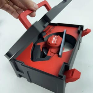 Pode incluir: Um cortador de pizza vermelho e preto com uma alça e uma lâmina. As palavras "PIZZA CUTTER" são impressas na lateral. O produto tem um design único e é segurado por uma mão.