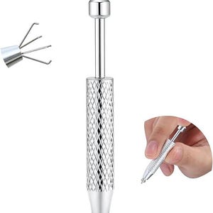 Könnte beinhalten: Ein silberfarbenes Schmuckwerkzeug mit einem diamantgemusterten Griff und einer kleinen, spitzen Spitze. Das Werkzeug hat eine abgerundete Oberseite und eine separate Nahaufnahme der Spitze mit mehreren Zinken. Eine Hand hält das Werkzeug.