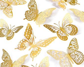 May include: A collection of gold-colored butterfly cutouts featuring intricate, lace-like patterns on their wings. Each butterfly is rendered in a metallic finish with delicate, symmetrical perforations throughout the wing structure, creating a light and airy appearance.