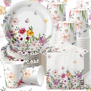 May include: A set of disposable party supplies featuring white paper plates, cups, and napkins decorated with a watercolor floral pattern of pink, purple, and yellow cosmos flowers, green stems, and small butterflies scattered across the white surfaces.