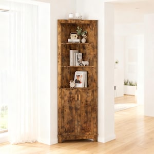 May include: A tall, triangular corner cabinet with a distressed brown wood grain finish. The unit features three open upper shelves holding books, a small radio, and decorative items, and a lower cabinet section with two doors and vertical slats.