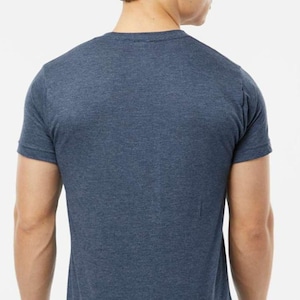 May include: A short-sleeved, navy blue t-shirt. The back view shows the shirt's crew neck and the texture of the fabric. The shirt is a solid color and appears to be made of a soft material.