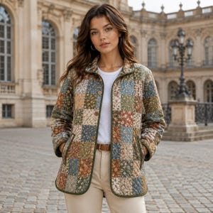 Puede incluir: Una chaqueta acolchada con un patr&oacute;n de patchwork de estampados florales en tonos apagados de azul, verde, marr&oacute;n y crema. La chaqueta tiene cuello, mangas largas, cierre frontal de botones y dos bolsillos laterales, sobre una camiseta blanca.