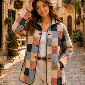 May include: A quilted jacket featuring a multi-colored patchwork pattern in shades of blue, pink, tan, and green. The jacket has a collared neckline, long sleeves, a button-front closure, and olive green trim along the edges and pockets.