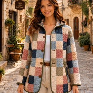 May include: A quilted jacket featuring a patchwork pattern of square blocks in muted shades of blue, pink, beige, and green. The jacket has a hood, a front button closure with brown buttons, and olive green trim along the edges and pockets.