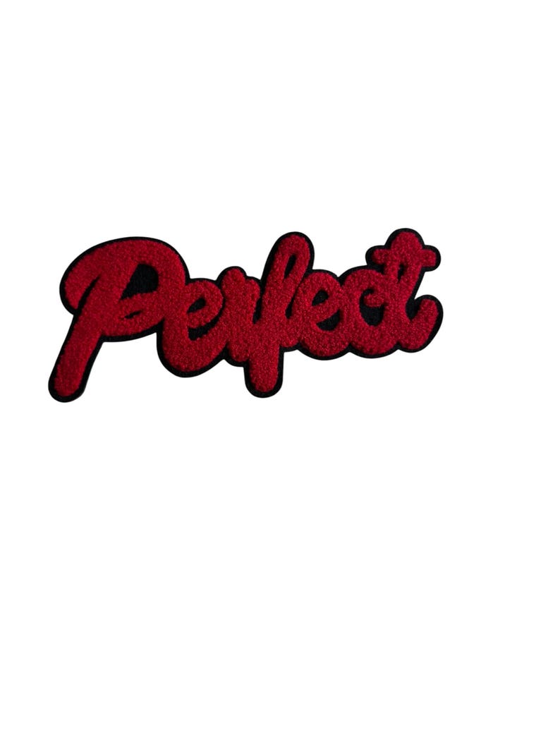 May include: A red embroidered patch with the word "Perfect" in a cursive font. The patch has a black border and a textured appearance, likely made of fabric or thread. The background is plain white.