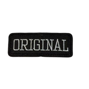 Peut inclure: Un écusson rectangulaire noir avec le mot "ORIGINAL" brodé en lettres blanches. L'écusson a une bordure noire et est probablement conçu pour être cousu ou repassé sur des vêtements ou des accessoires.