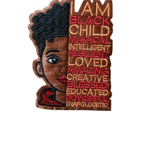 May include: Embroidered patch featuring a stylized illustration of a Black child's face. The patch includes the text "I AM BLACK CHILD" followed by words like "MAGICAL" and "LOVED" in red and brown.