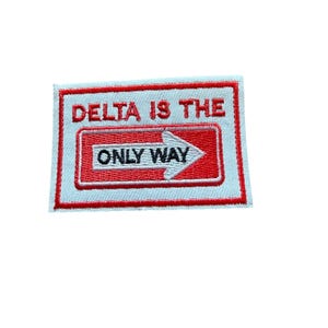 May include: A rectangular embroidered patch with a white background and a red border. The text reads DELTA IS THE ONLY WAY in red letters above a red rectangular sign with a white arrow pointing right and the words ONLY WAY in black text.