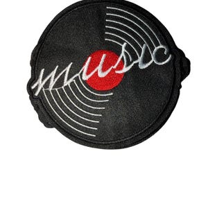 Puede incluir: Parche bordado con un diseño de disco de vinilo negro con líneas concéntricas blancas y la palabra "music" en escritura blanca. Un círculo rojo está en el centro del disco. El parche tiene un borde negro.