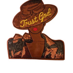Puede incluir: Parche de lentejuelas marrón con una ilustración estilizada de una persona con sombrero. El sombrero tiene el texto dorado "Trust God". La persona tiene labios rojos y la chaqueta está adornada con lentejuelas.