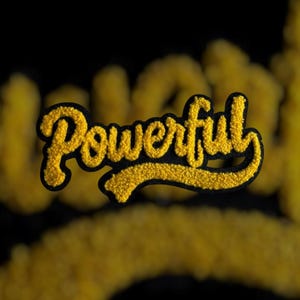K&ouml;nnte beinhalten: Ein gelber Chenille-Aufn&auml;her mit dem Wort "Powerful" in einer Schreibschrift, schwarz umrandet. Der Aufn&auml;her hat ein strukturiertes, flauschiges Aussehen vor einem verschwommenen schwarzen Hintergrund.