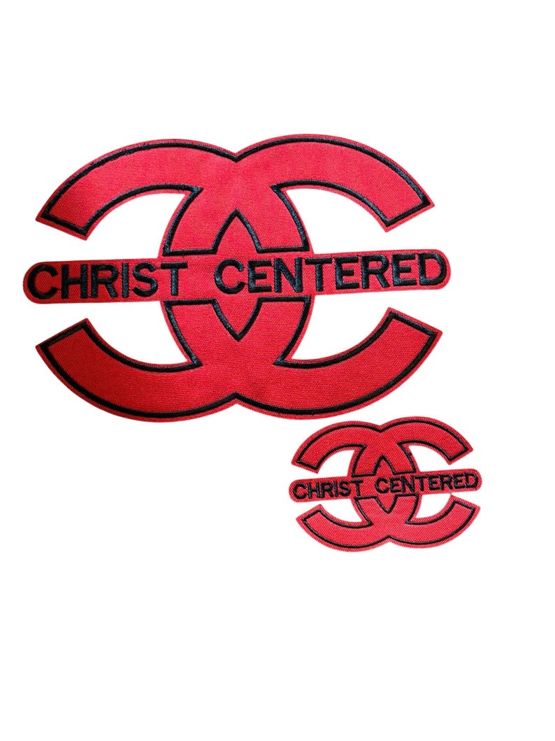 Puede incluir: Dos parches bordados rojos con bordes negros, cada uno con un dise&ntilde;o estilizado de doble C entrelazada. El texto CHRIST CENTERED est&aacute; bordado en negro en el centro de cada parche, colocado horizontalmente sobre las formas entrelazadas.