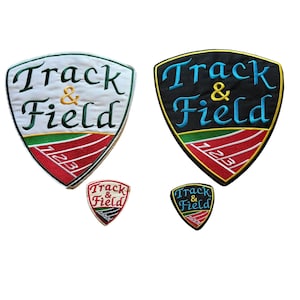 May include: Embroidered patches with the words "Track & Field" in green and blue, with a shield design. The patches feature a red, white, and green track design. Two larger patches and two smaller patches are shown.
