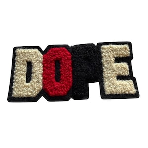 Peut inclure: Un écusson avec le mot "DOPE" dans un style de lettre universitaire. Les lettres "D" et "E" sont blanc cassé, le "O" est rouge et le "P" est noir. Chaque lettre a une bordure noire. L'écusson a un aspect texturé et flou.