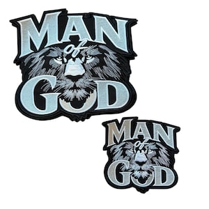 Peut inclure: Deux écussons brodés représentant une tête de lion stylisée en fil noir et blanc. Le texte MAN OF GOD est brodé en lettres bleu clair et blanches au-dessus et en dessous du lion. Les écussons ont une bordure noire et suivent le motif.