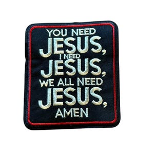 May include: A rectangular black embroidered patch with a red border. The patch features white stitched text that reads: YOU NEED JESUS, I NEED JESUS, WE ALL NEED JESUS, AMEN. The design has a textured fabric appearance with clear, bold lettering.