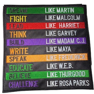 May include: Black square patch with embroidered text in various colors. The left side lists words like DREAM, FIGHT, and LEAD. The right side lists names like MARTIN, MALCOLM, and HARRIET. The patch is a motivational or inspirational item.