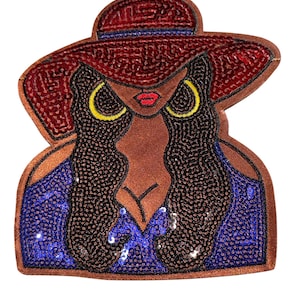 Peut inclure: Écusson brodé représentant une femme portant un chapeau à larges bords bordeaux avec une bande bleue. Elle a de grands créoles jaunes, des lèvres rouges et de longs cheveux noirs. Son haut est bleu et orné de sequins.