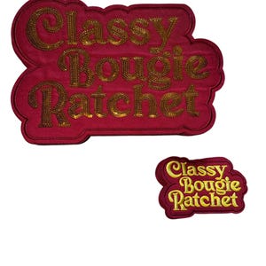 May include: Two embroidered patches with the words "Classy Bougie Ratchet" in gold lettering on a red background. The larger patch is a rounded rectangle, and the smaller one is a smaller version of the same design.