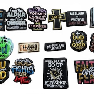 May include: A collection of embroidered patches with religious themes. The patches feature phrases like "Blessed," "Fear God," and "God is Good." Colors include black, gold, white, and various other colors. The patches are of various shapes and sizes.