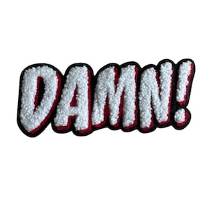 Può includere: Toppa ricamata bianca, rossa e nera con la scritta "DAMN!" in un font in stile fumetto. Le lettere bianche hanno un aspetto strutturato, delineate in rosso e nero.