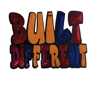 May include: A black sequined patch featuring the phrase "BUILT DIFFERENT" in bold, bubble letters. The letters are in shades of red, orange, and blue. This patch is designed for application on clothing or accessories.