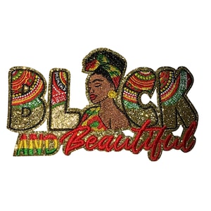 Peut inclure: Un écusson doré à paillettes avec les mots "BLACK AND BEAUTIFUL" en rouge et or. Le mot "BLACK" présente un motif coloré, et la lettre "C" représente le visage d'une femme portant un foulard.