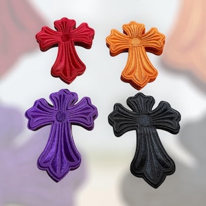 Peut inclure: Quatre ornements décoratifs en forme de croix, de couleurs rouge, orange, violet et noir. Chaque croix présente un motif détaillé et texturé avec des bords arrondis et un élément central circulaire. Les croix sont présentées sur un fond doux et neutre.