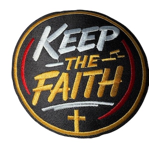 Peut inclure: Écusson brodé avec l'inscription "KEEP THE FAITH" en lettres blanches et dorées sur fond noir. L'écusson a une bordure dorée avec des accents rouges et une croix en bas.