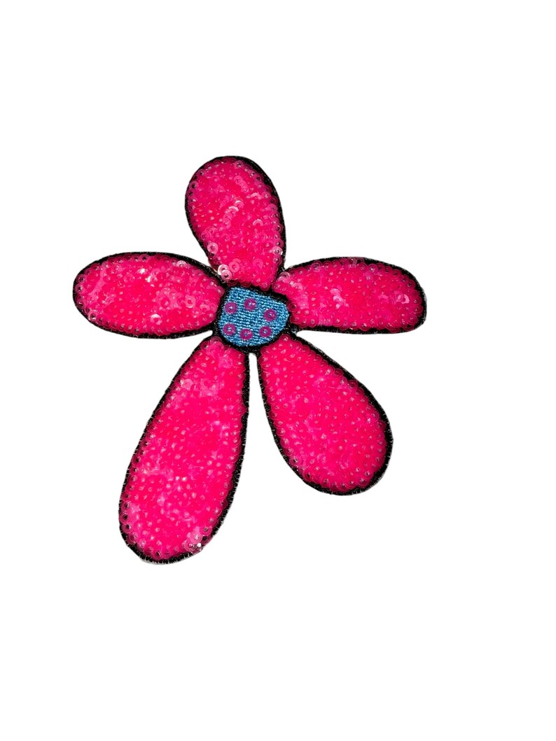 Puede incluir: Aplique en forma de flor rosa brillante con cinco p&eacute;talos cubiertos de lentejuelas y contorneados en negro. El centro de la flor es azul y tiene una textura.