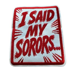 May include: A rectangular embroidered patch with a white background and a thick red border. The text "I SAID MY SORORS..." is stitched in red, featuring a distressed, jagged font style with radiating red lines extending from the letters.