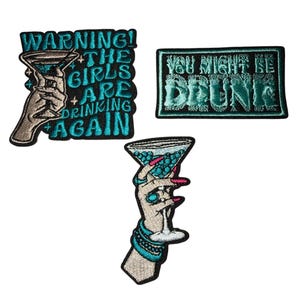 Peut inclure: Trois écussons brodés avec des motifs de cocktails. L'un d'eux dit "WARNING! THE GIRLS ARE DRINKING AGAIN" avec une main tenant un martini. Un autre dit "YOU MIGHT BE DRUNK". Le troisième montre une main tenant un verre à martini.