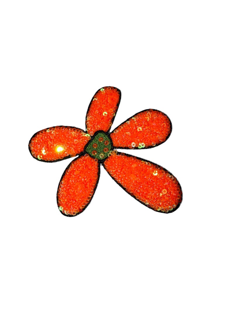 Puede incluir: Aplicaci&oacute;n decorativa de flores con cinco p&eacute;talos naranjas y un centro verde. Los p&eacute;talos est&aacute;n cubiertos de lentejuelas y delineados en negro. Dise&ntilde;ado para coser o pegar sobre tela.