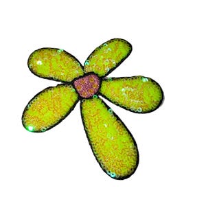 Puede incluir: Una flor decorativa con cinco p&eacute;talos, cada uno de un amarillo verdoso vibrante, delineados en negro. Los p&eacute;talos est&aacute;n cubiertos de lentejuelas, y el centro es rosa texturizado. La flor est&aacute; sobre un fondo blanco.